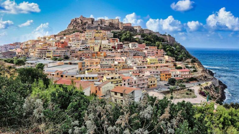 Nell'immagine si vede la città di Castelsardo, circondata dalla vegetazione e dal mare limpido della Sardegna.