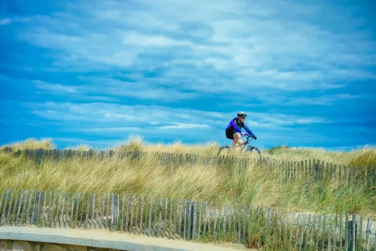 In the picture a man that rides a bike in a green meadow in Sardinia.