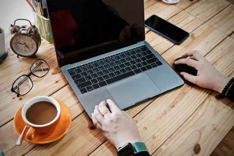 In the picture a person that works with a laptop in a hotel.